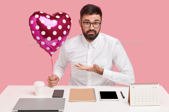 Puzzled office worker has secret admirer, asks whose valentine it is, holds balloon, dressed in whit