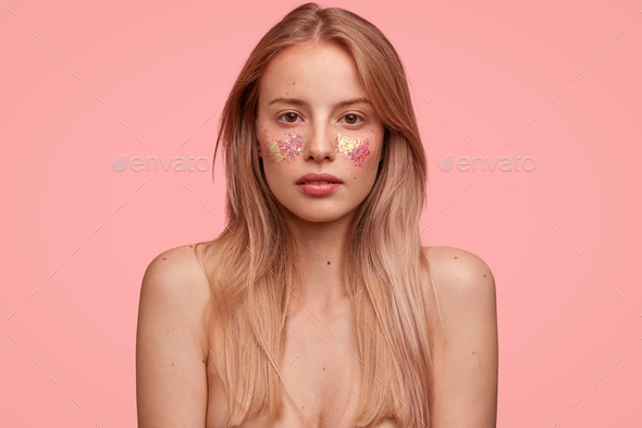 Indoor Shot Of Gorgeous Female Lady Poses With Naked Body Decorated With Glitters Against Pink