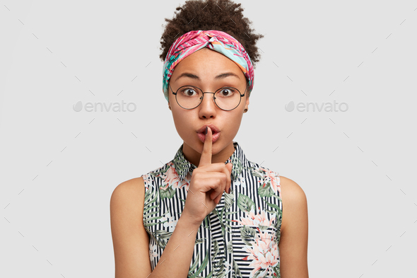 Secret young African American housewife shows silence sign, asks to be silent as her child is sleepi