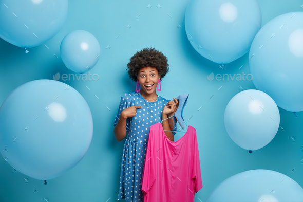 Positive ethnic lady points at herself asks for advice what to dress on party has glad expression ho