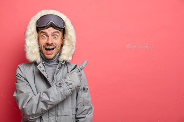 Happy surprised excited man snowboard rider in winter jacket relaxes after skiing has active day of