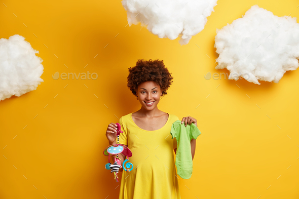 Pregnancy and motherhood concept. Happy expectant mother with big abdomen anticipates baby holds mob - Stock Photo - Images