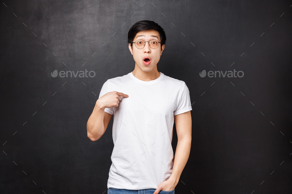 Portrait of surprised confused handsome asian guy being chosen or named, pointing himself with