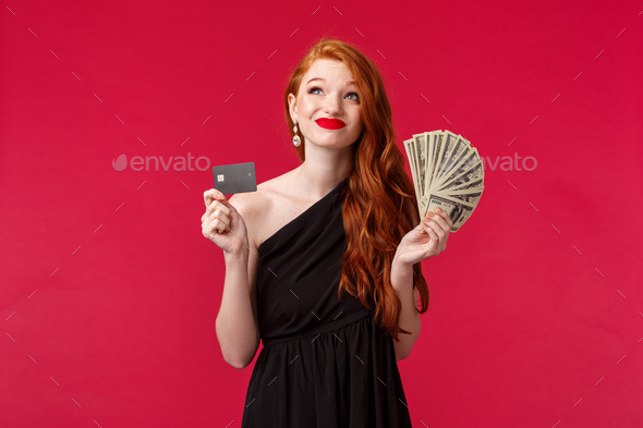 Luxury, beauty and money concept. Dreamy rich and lucky good-looking redhead woman thinking how