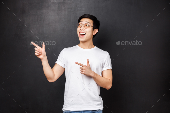 Portrait of enthusiastic and excited handsome chinese guy in white shirt, open mouth amused looking