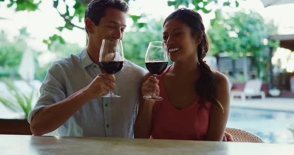 Couple Enjoying Glass of Wine at Luxury Resort alt