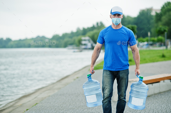 Delivery water man wear protective face medical mask during coronavirus pandemia.