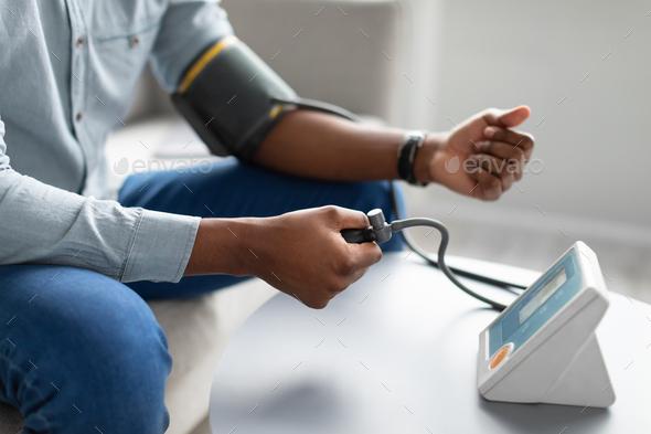Black Man Measuring Arterial Blood Pressure Having Hypertension Indoors, Cropped - Stock Photo - Images