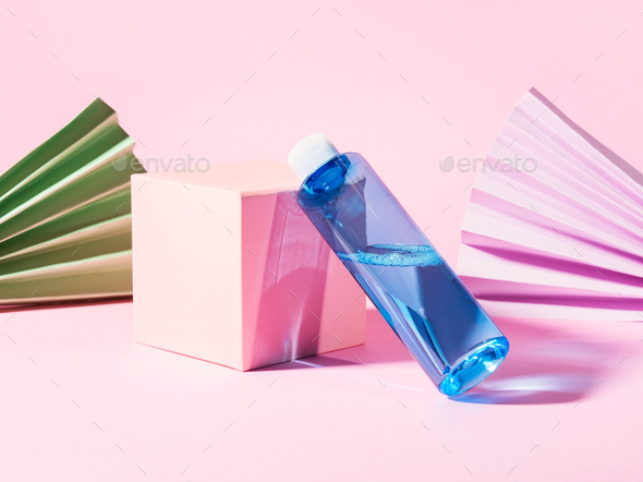 Blue skin care toner bottle on pink geometrical background