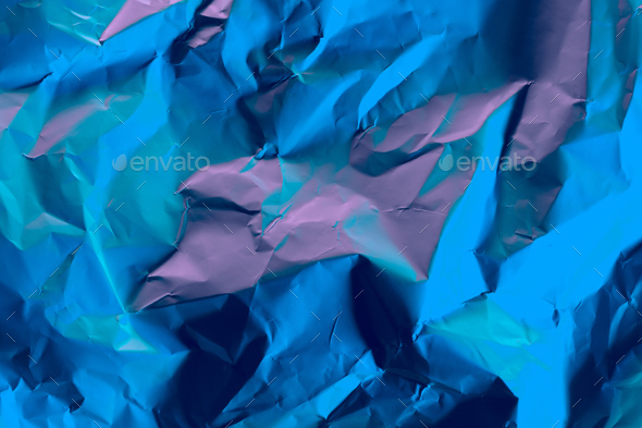 Crushed paper background in vibrant bold gradient holographic neon colors.  Flat lay. Top view. Stock Photo by natika