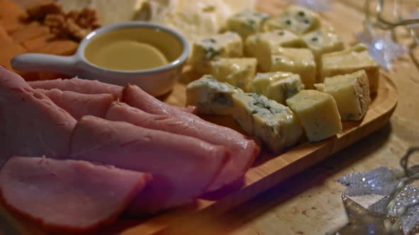 Set of Different Cheeses Pork Ham Honey and Greek Nuts on a Wooden Tray alt