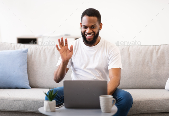 African Guy Video Calling Using Laptop Waving Hello At Home