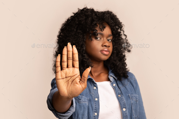 Black woman showing her palm, stop gesture