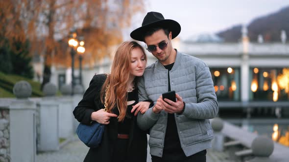 A Man and a Woman are Walking Along the Quay