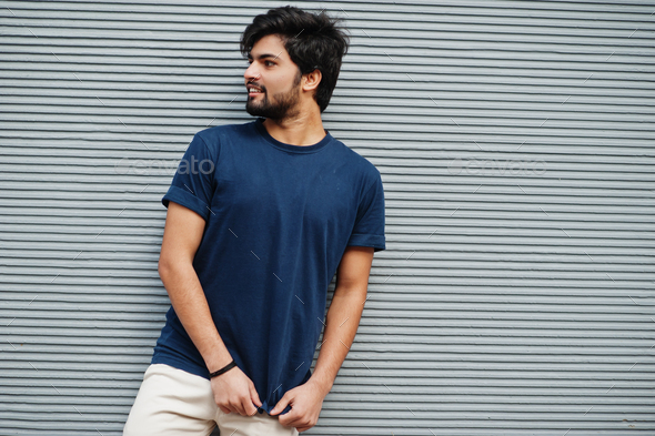 A young person with a relaxed pose leaning against a brick wall.  Royalty-Free Stock Image - Storyblocks