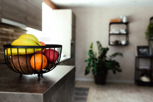 Fruits in fruit bowl on bar counter in stylish loft kitchen. Blurred  background Stock Photo by LenorIv