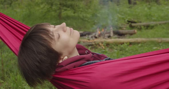 Close Up Zooming Video of Woman Dreaming in Red Hammock in Wonderful Woods Slow Motion alt