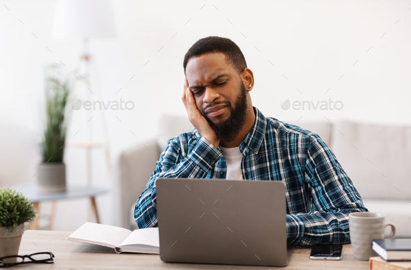 Unhappy African Man At Laptop Working Online Sitting In Office
