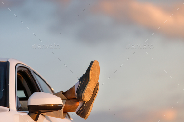 Man driver put feet on car window, relaxing, resting at sunset - Stock Photo - Images