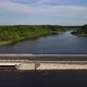 Dam Road with Vehicles Crossing Calm River - VideoHive Item for Sale