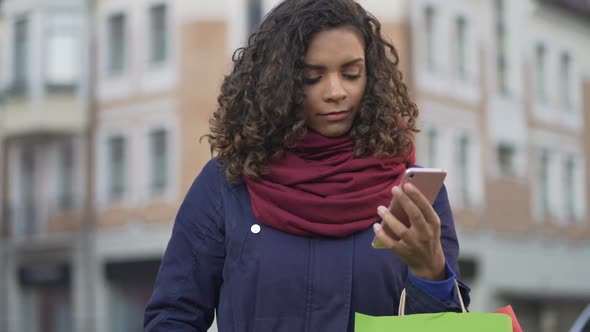 Woman Choosing Gifts Online Browsing Sales in Web Stores on Smartphone alt