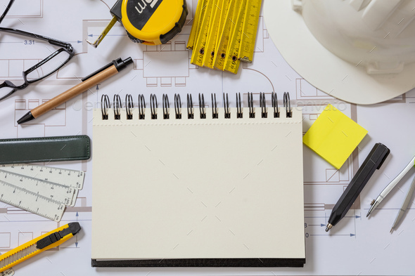 Residential building drawings and blank notepad on an office desk.  Construction concept. Stock Photo by rawf8