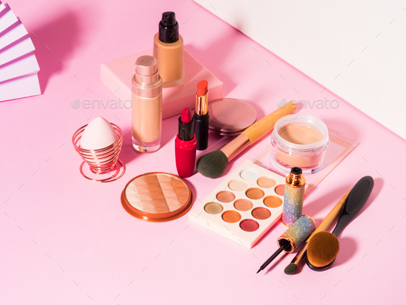 Different make up beauty cosmetics products on pink