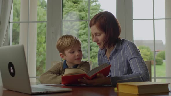 Young 30s Mother Reading Book with Her Son at Home alt