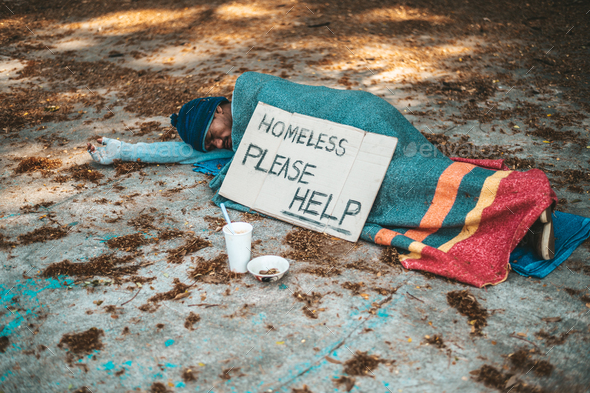 Beggars sleep on the street with homeless messages please help.