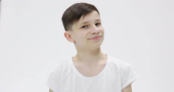 Handsome teen 14s in white t-shirt happily smiling isolated over white background in studio. People 