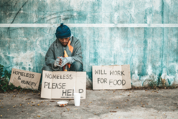 The beggars sat beside the street with a homeless message. Please help and work with food.