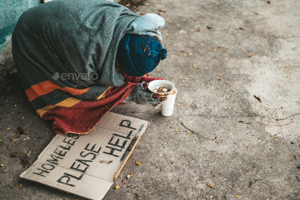 Beggars sitting on the street with homeless messages please help.