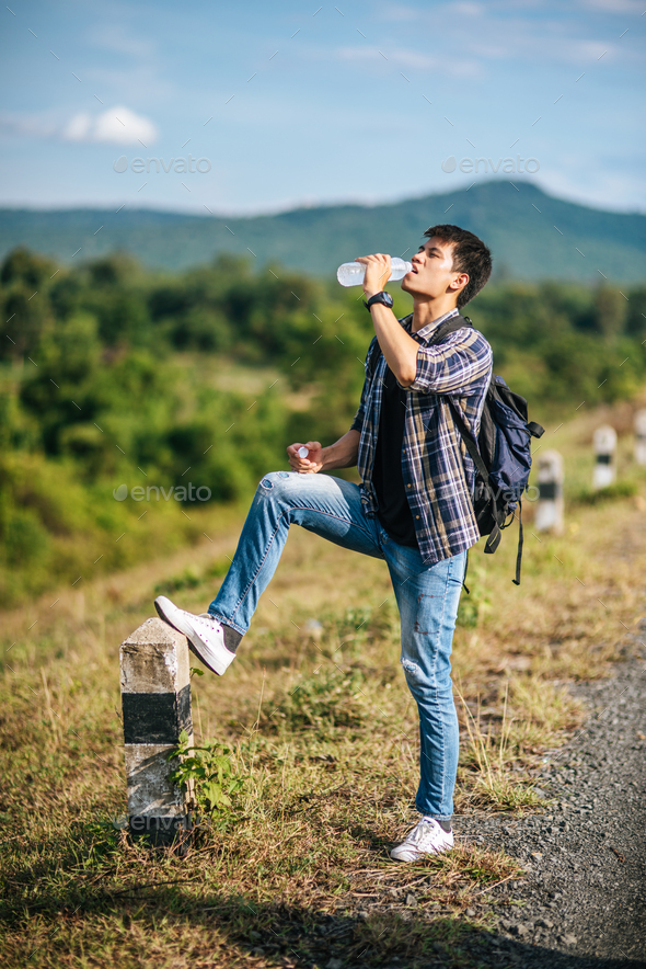 Male tourists drink water and feet stepped on kilometers.
