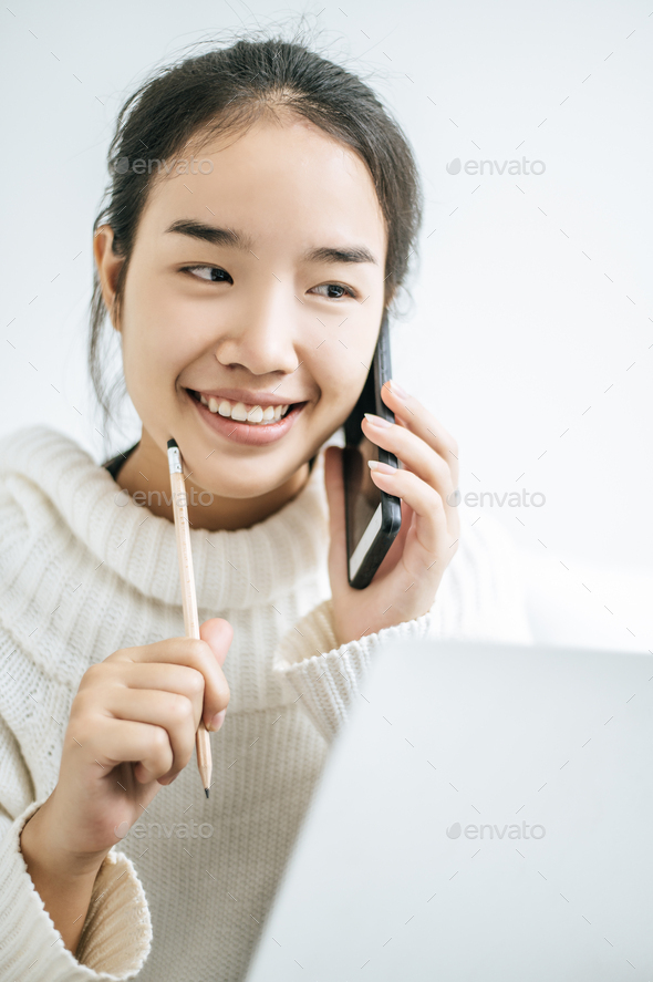 The Girl Wore A White Shirt Talking On The Phone And Happily Holding