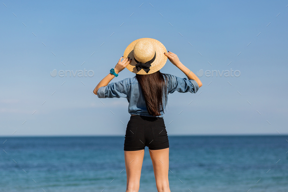 View from back. Sexy woman in straw hat