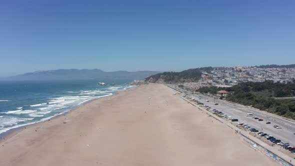 Wide rising aerial shot of Ocean Beach towards Land's End in San Francisco. 4K alt