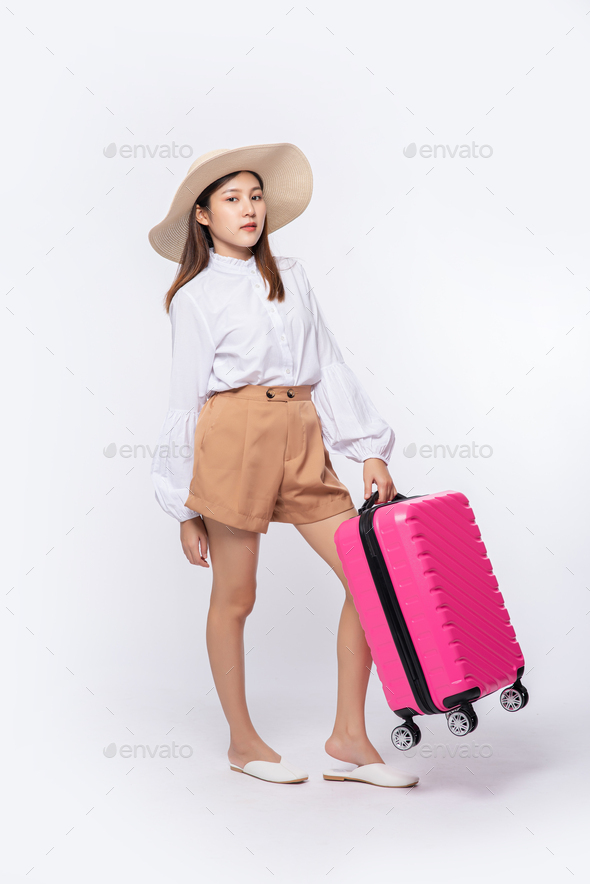 Woman wearing a hat, glasses, and handles of suitcases to travel.