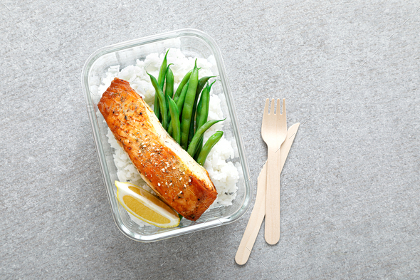 Lunch box containers with grilled salmon fish fillet, rice and green beans