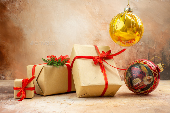 bottom view xmas gifts in brown paper ribbon xmas tree toy on newspaper on dark background
