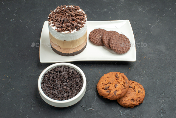 front view chocolate cake and biscuits on white rectangular plate bowl with dark chocolate biscuits