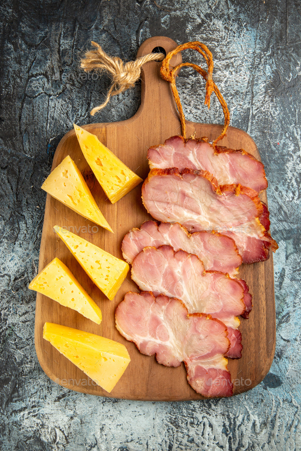top view meat slices cheese slices on cutting board on grey background