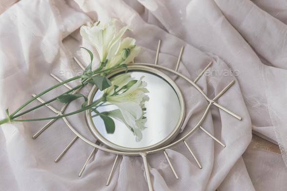 Beautiful alstroemeria flowers on boho mirror on soft fabric. Spring aesthetics. Womens day