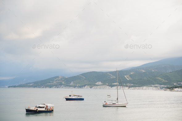 small tourist yachts and fishing boats without people in bad weather in bay