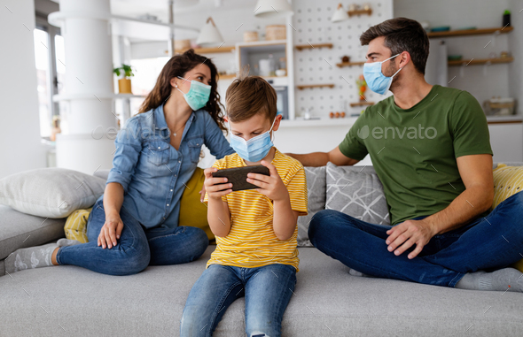 Young modern quarantined coronavirus family in medical masks