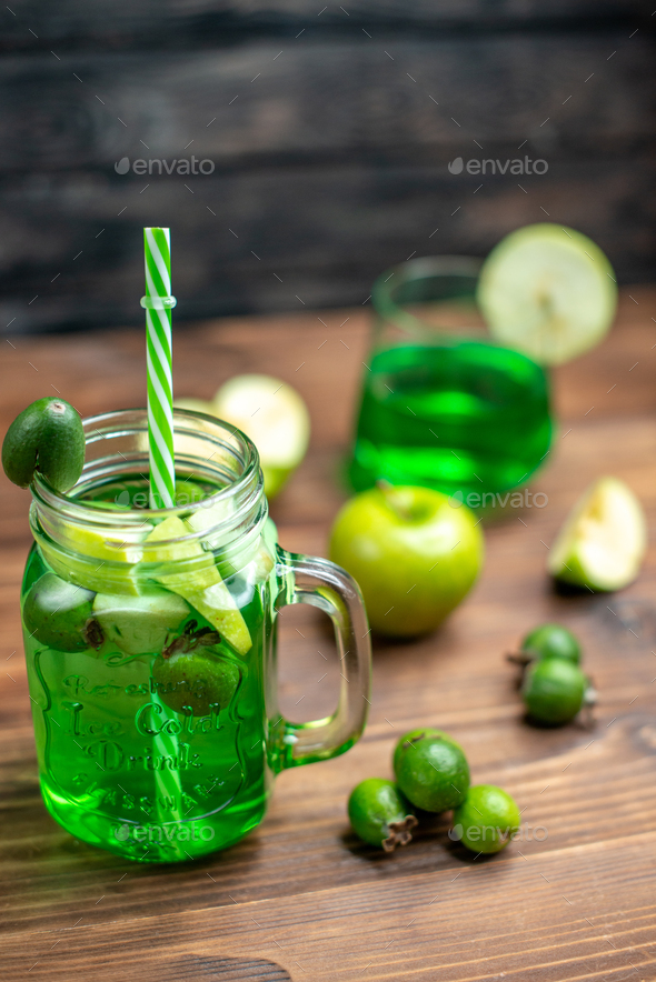 front view green feijoa juice inside can with green apples on wooden desk bar fruit color drink