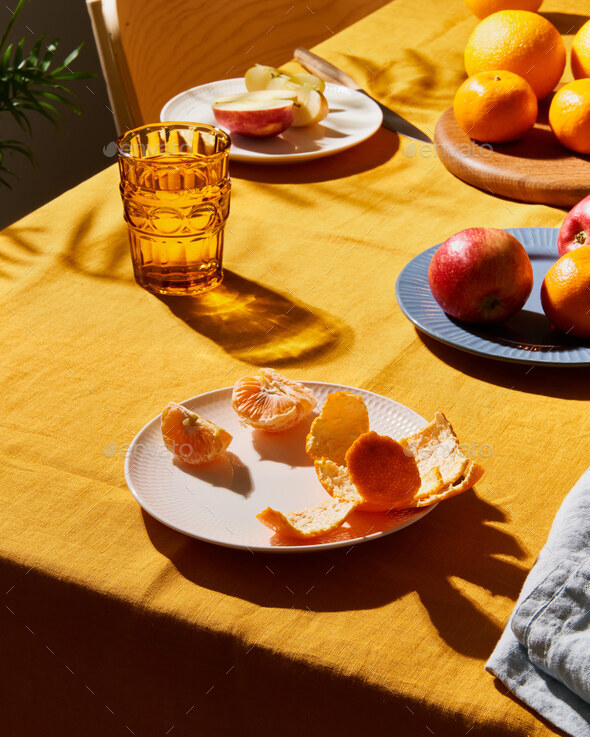 Food, breakfast with fruit. Table covering bright yellow linen tablecloth, sunlight deep hard shadow - Stock Photo - Images