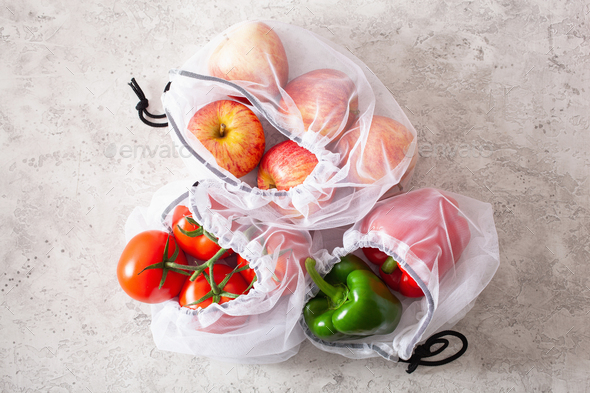 apples tomatoes bell peppers vegetables in reusable mesh nylon bag, plastic free zero waste concept