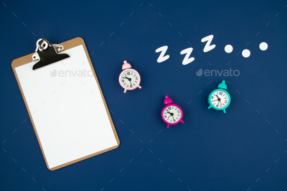 Snoring classic alarm clock on blue pastel trendy background. Flat lay, top view mock up