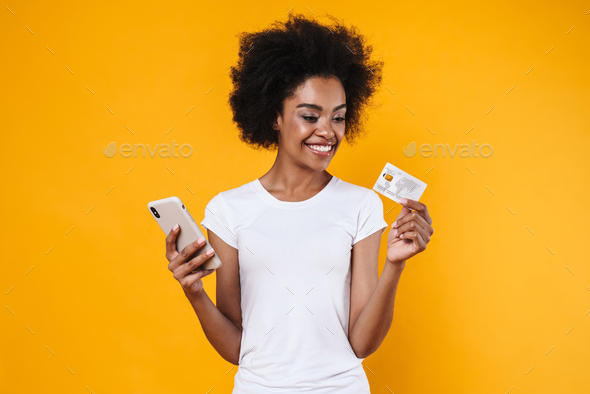 Happy young african american woman holding cellphone and credit card
