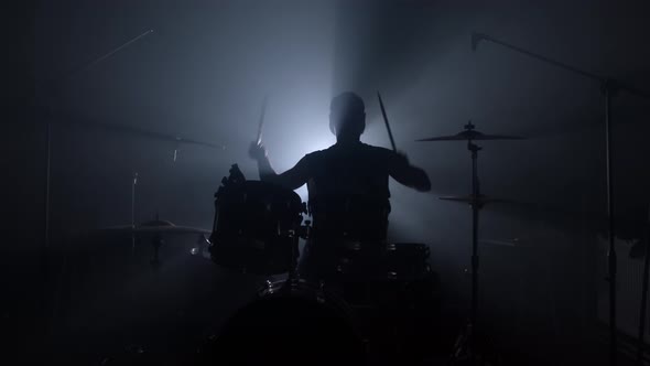 Silhouette of a Male Drummer Playing Drums